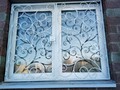 Кованая решетка на окно белая с завитками - фото
